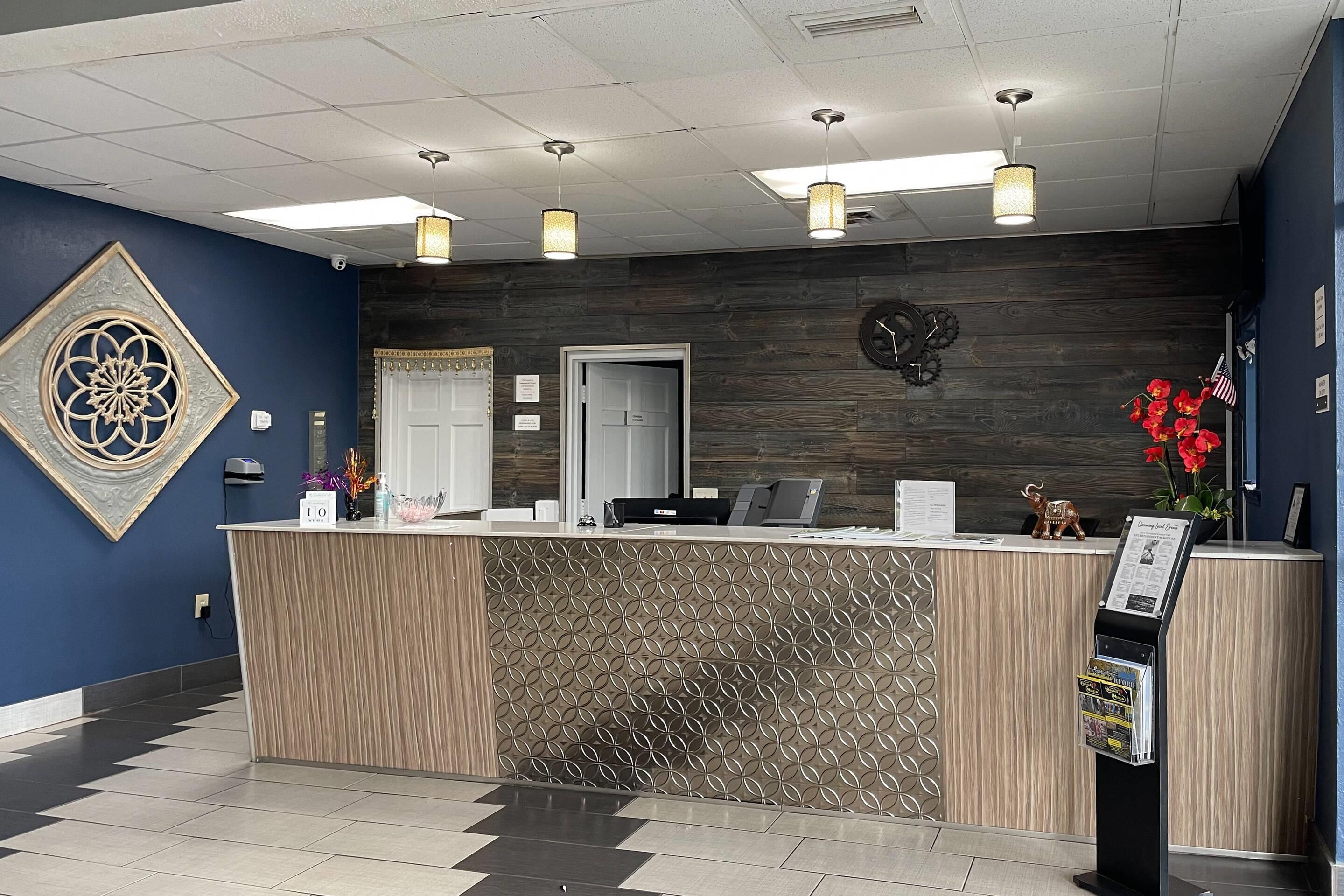 A reception desk with a patterned backdrop, a clock, and a small American flag decoration.