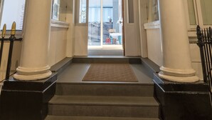 The entrance to The Victoria Inn with classical architecture, including columns and a sign above the door. - Victoria Inn (London)