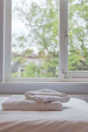 Enjoy a restful stay in this serene room with a comfortable bed and a view of the surrounding greenery.
