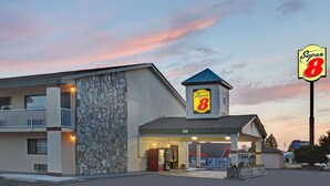 A Super 8 motel with a stone facade, a balcony, and a covered entrance. - Super 8 by Wyndham Shelby (Shelby)
