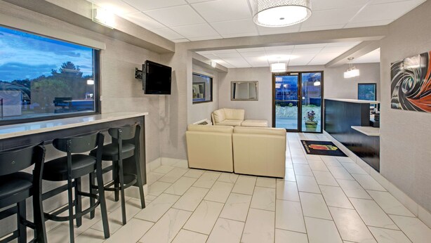 A modern hotel lobby with a bar area, seating, and a large window offering a view of the outside. - Super 8 by Wyndham Shelby (Shelby)