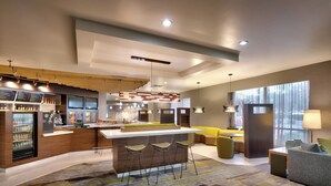 Una cocina moderna con una isla central, barra y zona de estar.