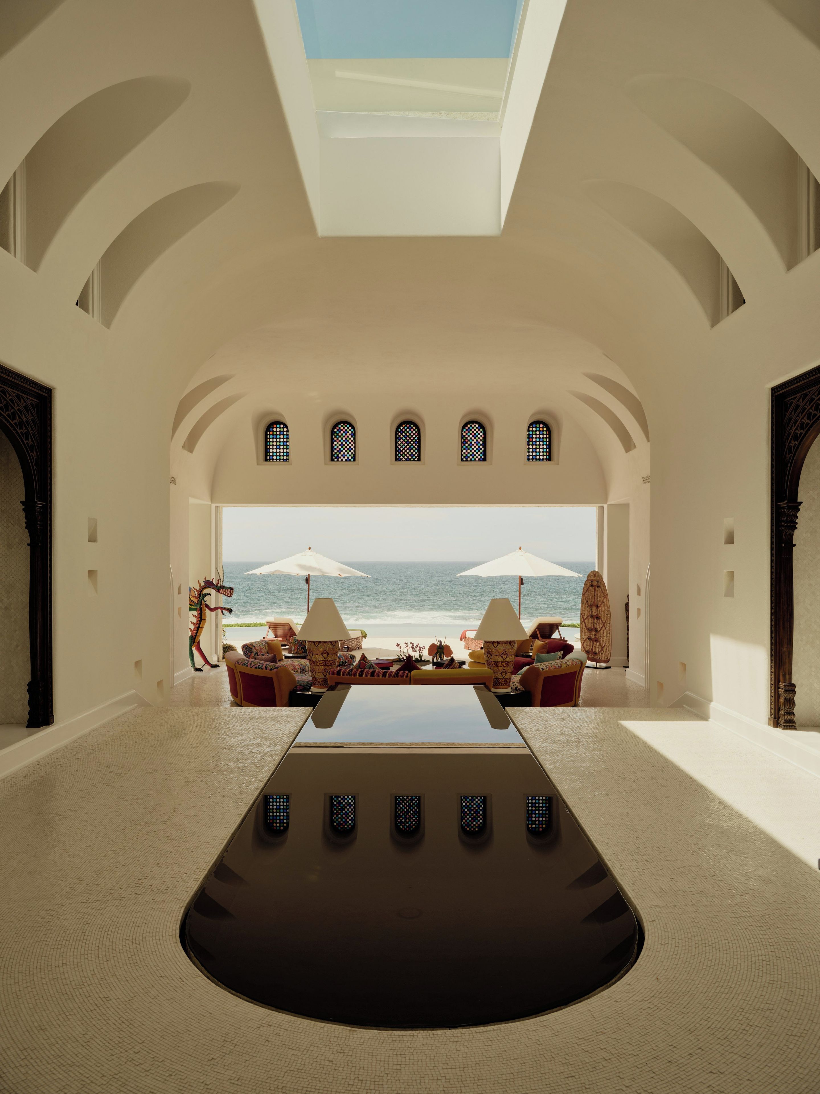 A spacious room with a large table, comfortable seating, and a view of the sea.