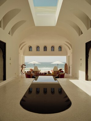 A spacious room with a large table, comfortable seating, and a view of the sea. - Las Ventanas al Paraiso, A Rosewood Resort (San José del Cabo)