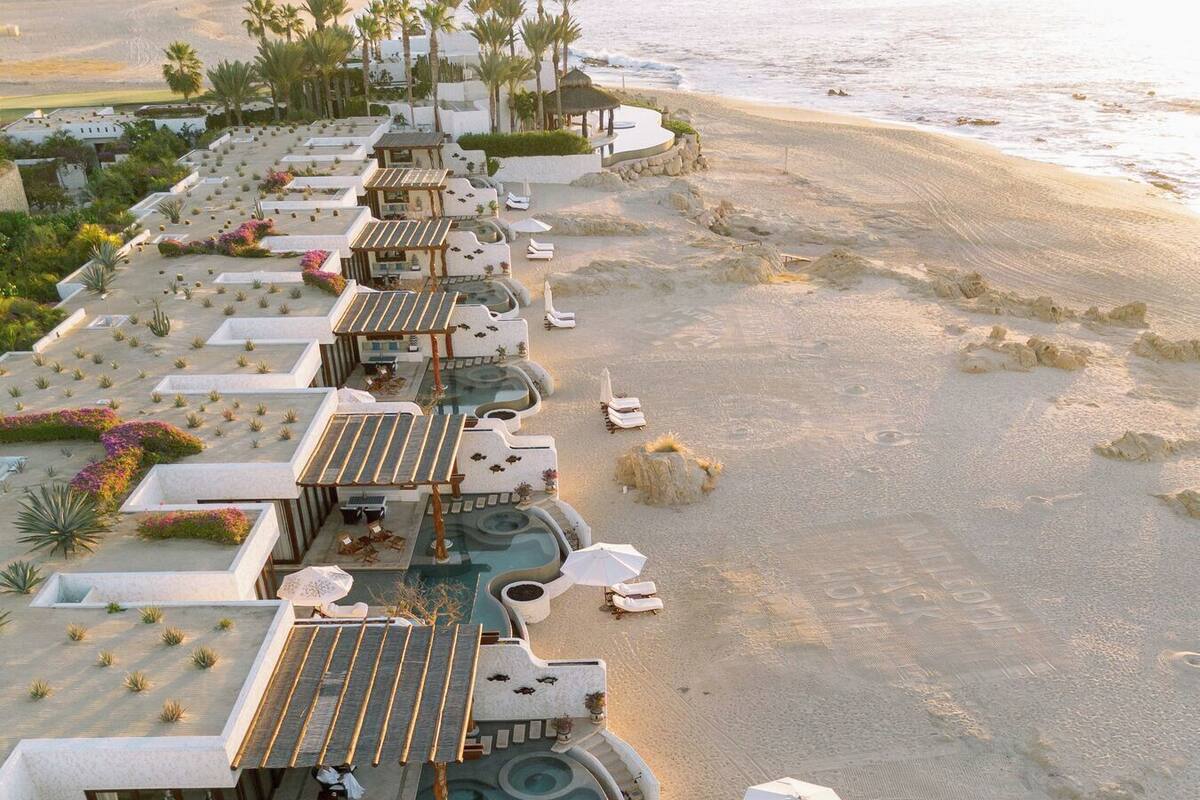 A resort with multiple swimming pools, sun loungers, and a beach area.