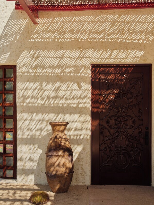 A building facade with a large decorative door, a window with multiple panes, and a large vase. - Las Ventanas al Paraiso, A Rosewood Resort (San José del Cabo)