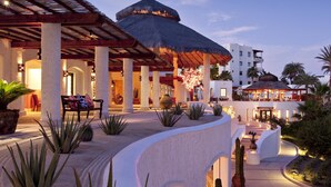 A resort with a thatched-roof structure, palm trees, and a pool area. - Las Ventanas al Paraiso, A Rosewood Resort (San José del Cabo)