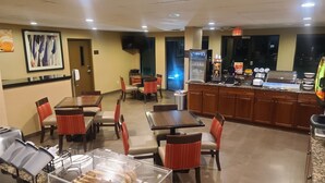 A restaurant with tables and chairs, a buffet area, and a counter with a coffee machine. - Comfort Inn & Suites Leeds I-20 (Leeds)