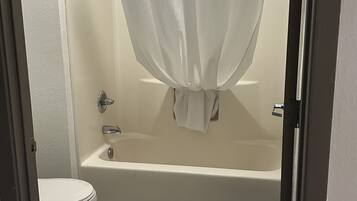 Un baño con bañera, inodoro y cortina de ducha.