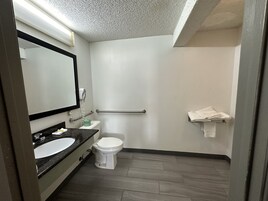 Un baño moderno con un lavamanos blanco, un inodoro y un espejo.