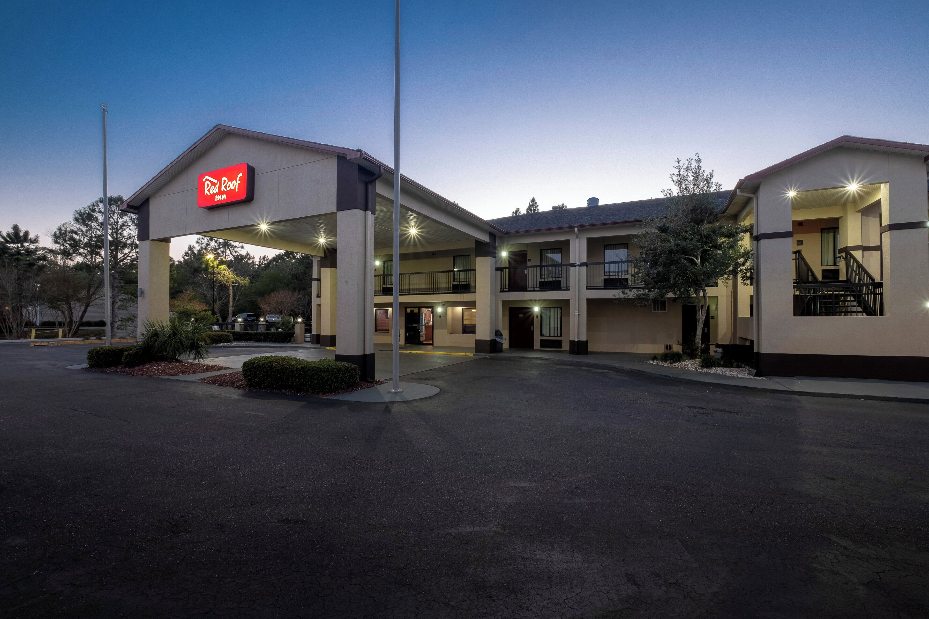 A Red Roof Inn with a covered entrance, multiple floors, and a parking lot.