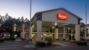 Ein Red Roof Inn mit einer zweistöckigen Struktur, mehreren Balkonen und einem Parkplatz.