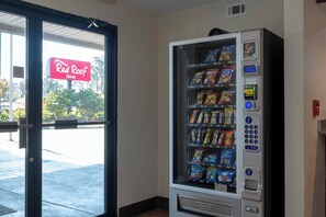 Un distributeur automatique de collations, avec une enseigne Red Roof Inn en arrière-plan.