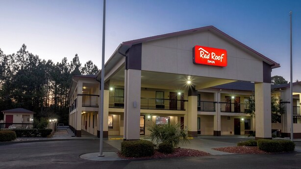 Ein Red Roof Inn mit zweistöckiger Bauweise, Außenbereich und einem gut beleuchteten Eingang.