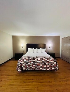 Une chambre à coucher avec un lit, deux tables de chevet et une porte.
