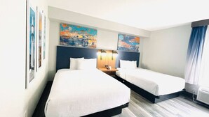 A hotel room with two beds, a wooden headboard, wall art, and a nightstand with a lamp. - La Quinta Inn & Suites by Wyndham Birmingham Homewood (Birmingham)
