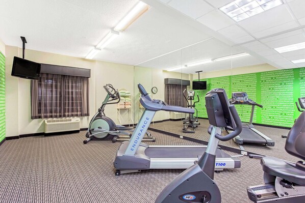 Et fitnesscenter med løbebånd, spinningcykler og spejlvæg.