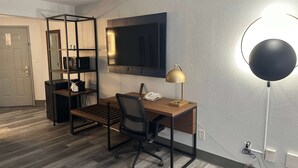 A modern office space with a desk, chair, and a large flat-screen TV mounted on the wall. - La Quinta Inn & Suites by Wyndham Birmingham Homewood (Birmingham)