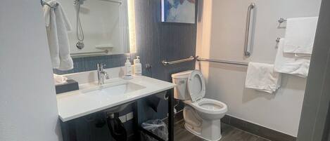 A modern bathroom with a sink, toilet, and shower area.