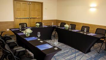 A conference room with a long table, chairs, and a wooden door.