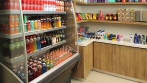 A beverage refrigerator stocked with various drinks, a shelf with snacks, and a counter with personal care items. - Holiday Inn Express Torreon by IHG (Torreón)