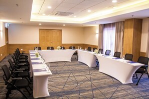 Una sala de conferencias con una mesa larga, sillas y una puerta.