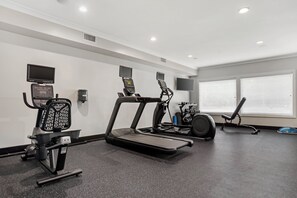 A gym with treadmills, a stationary bike, and a rowing machine.