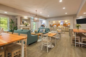 A modern hotel lobby with seating areas, a dining space, and a breakfast bar. - Holiday Inn Express Fairhope by IHG (Fairhope)