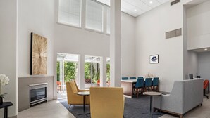 A spacious lobby with a fireplace, comfortable seating, and a dining area. - Holiday Inn Express Fairhope by IHG (Fairhope)