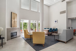 A spacious lobby with a fireplace, comfortable seating, and a dining area. - Holiday Inn Express Fairhope by IHG (Fairhope)