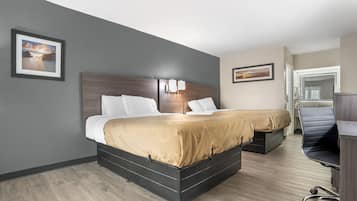 Una habitación de hotel con una cama grande, un escritorio y una silla.