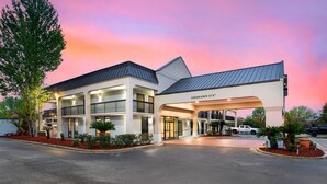 A multi-story hotel with a modern design, featuring a covered entrance and multiple balconies.