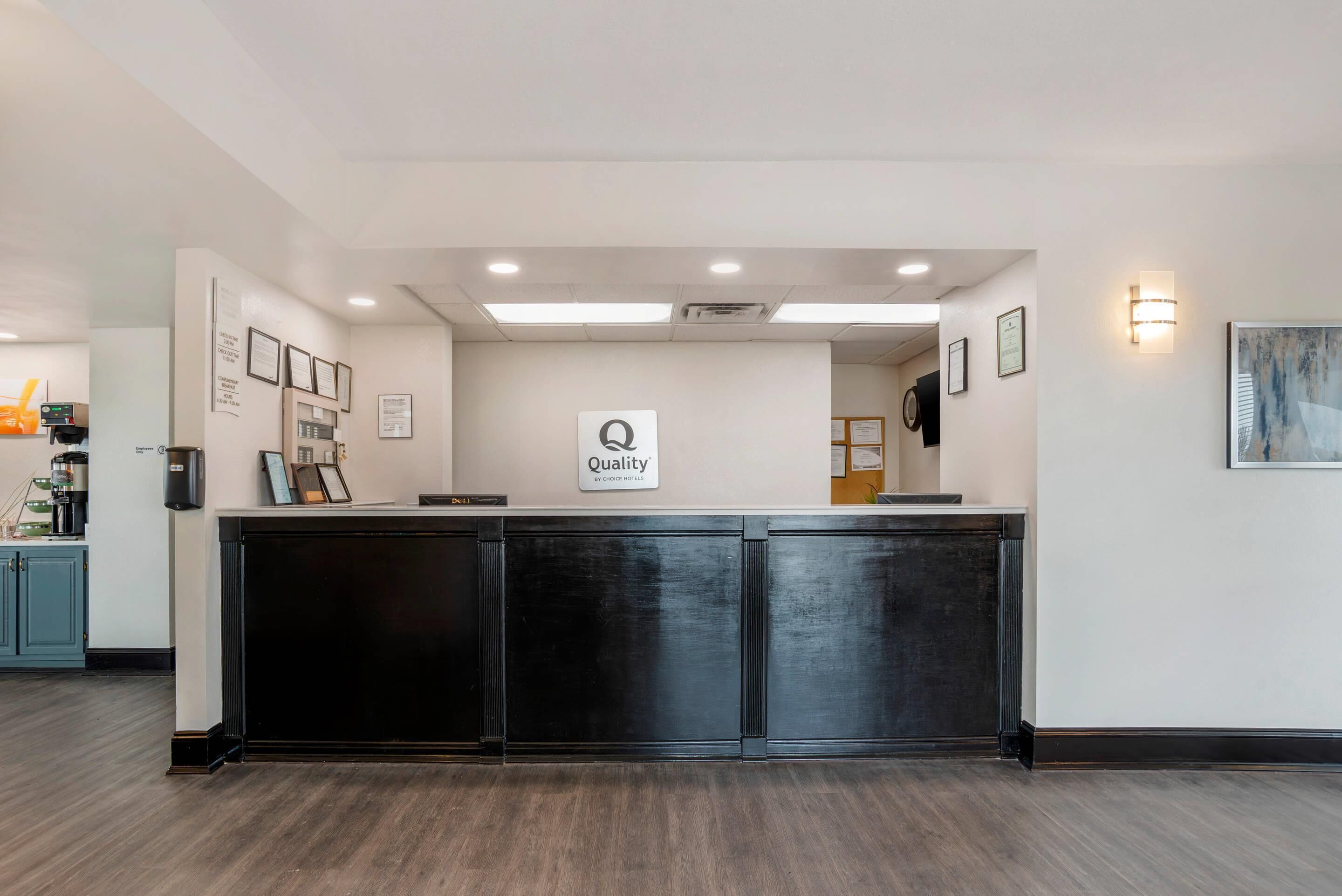 Un comptoir d’accueil avec une pancarte indiquant : « Qualité garantie par Choice Hotels ».