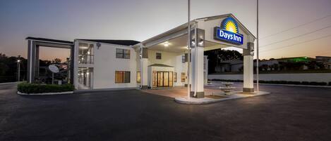 Un Days Inn con un grande cartello, un ingresso coperto e una facciata ben illuminata.