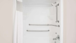 A white bathtub with two grab bars, a showerhead, and a faucet. - Days Inn by Wyndham Eufaula AL (Eufaula)