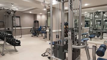 Un gimnasio con diversos equipos de ejercicio, como mancuernas, bancos y máquinas de pesas.