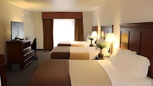 A hotel room with a large bed, a smaller bed, a desk with a chair, a mirror, and a window with curtains. - Rodeway Inn Santa Clara El Camino Real (Santa Clara)