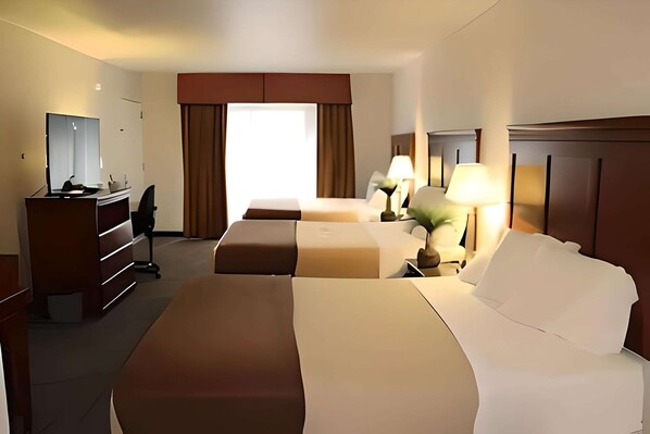Une chambre d’hôtel avec un grand lit, un plus petit lit, un bureau avec une chaise, un miroir et une fenêtre avec des rideaux.