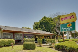 Un motel con un letrero que anuncia 'Denny's' y 'Vagabond Inn'.