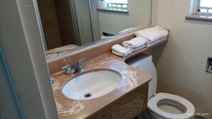 A bathroom with a marble sink, a toilet, and a towel rack.