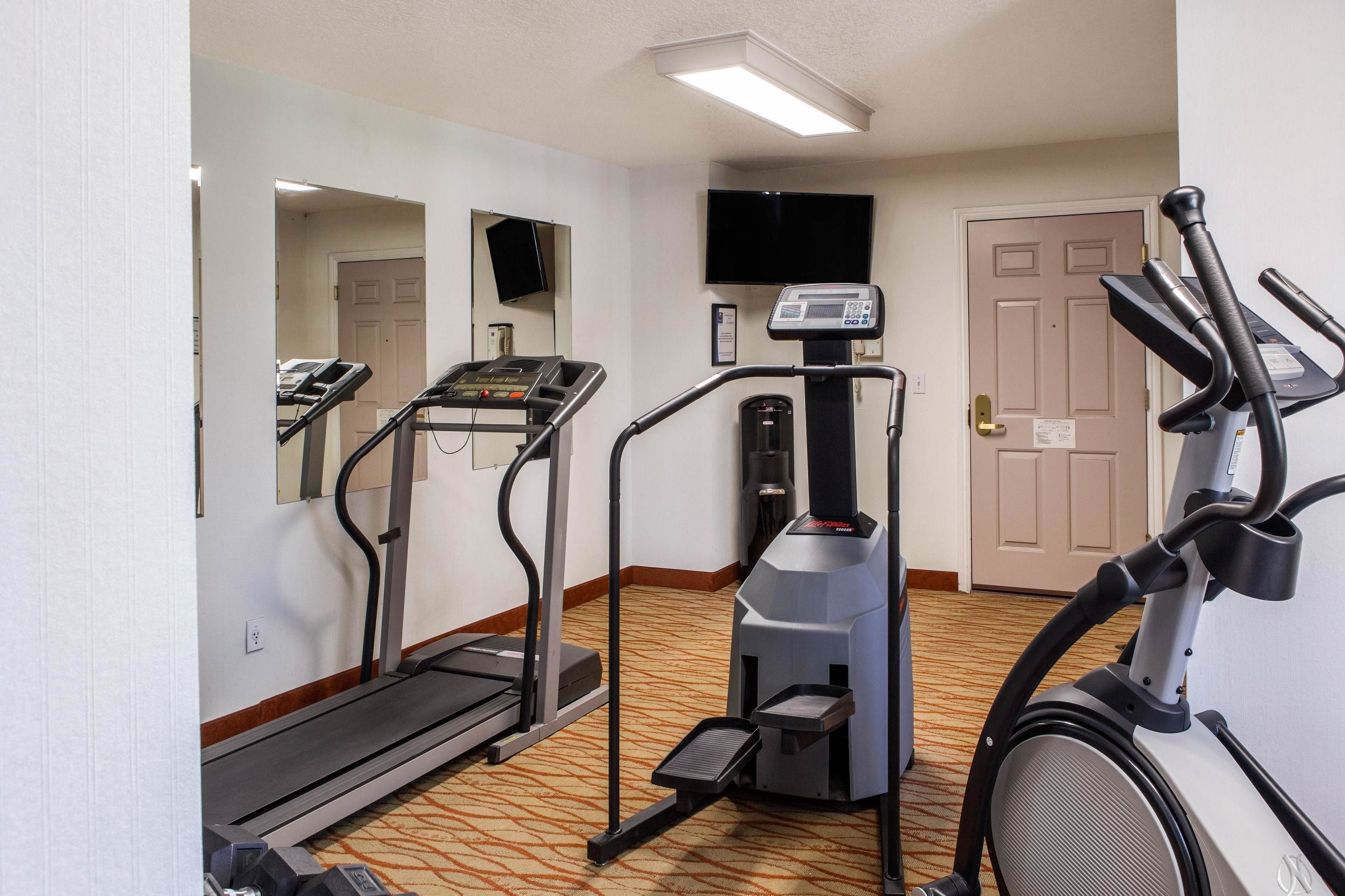 A hotel fitness room with treadmills, a stair climber, and a stationary bike.