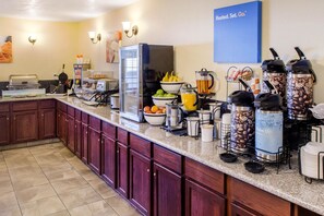 A breakfast bar with a variety of food and drink options, including fruits, coffee, and juice dispensers. - Comfort Inn Mount Shasta Area (Weed)