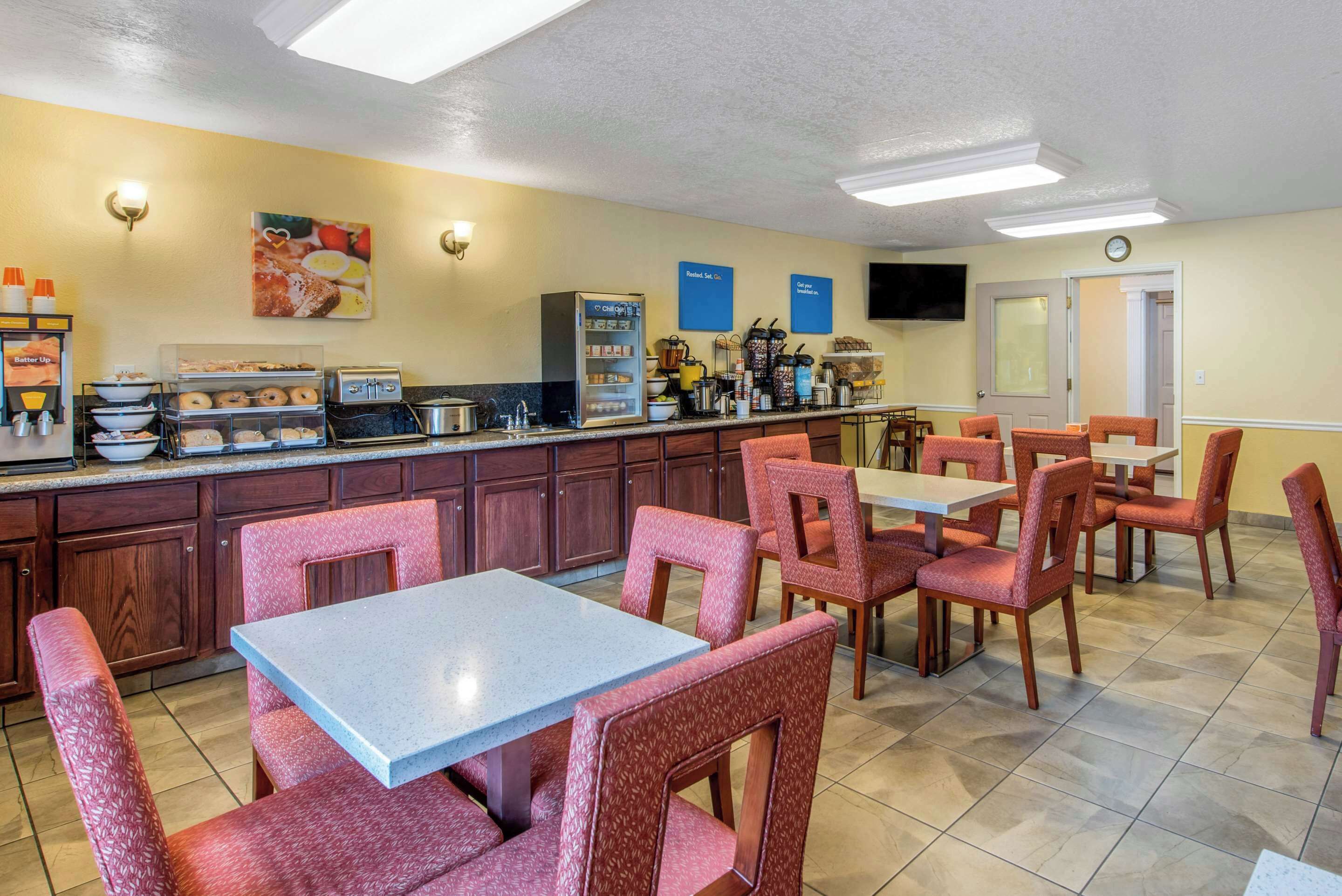 A breakfast area with a counter, seating, and a clock on the wall.