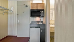 A compact kitchenette with a microwave, stove, and refrigerator.