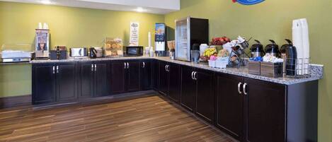 A breakfast area with a coffee machine, microwave, and refrigerator.