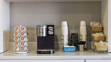 Un espace dédié au café, équipé d’une machine Keurig, de gobelets à café jetables et d’un support pour les capsules de café.