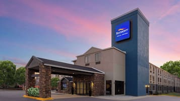 A Baymont Inn & Suites with a prominent blue sign, a covered entrance, and a stone facade.