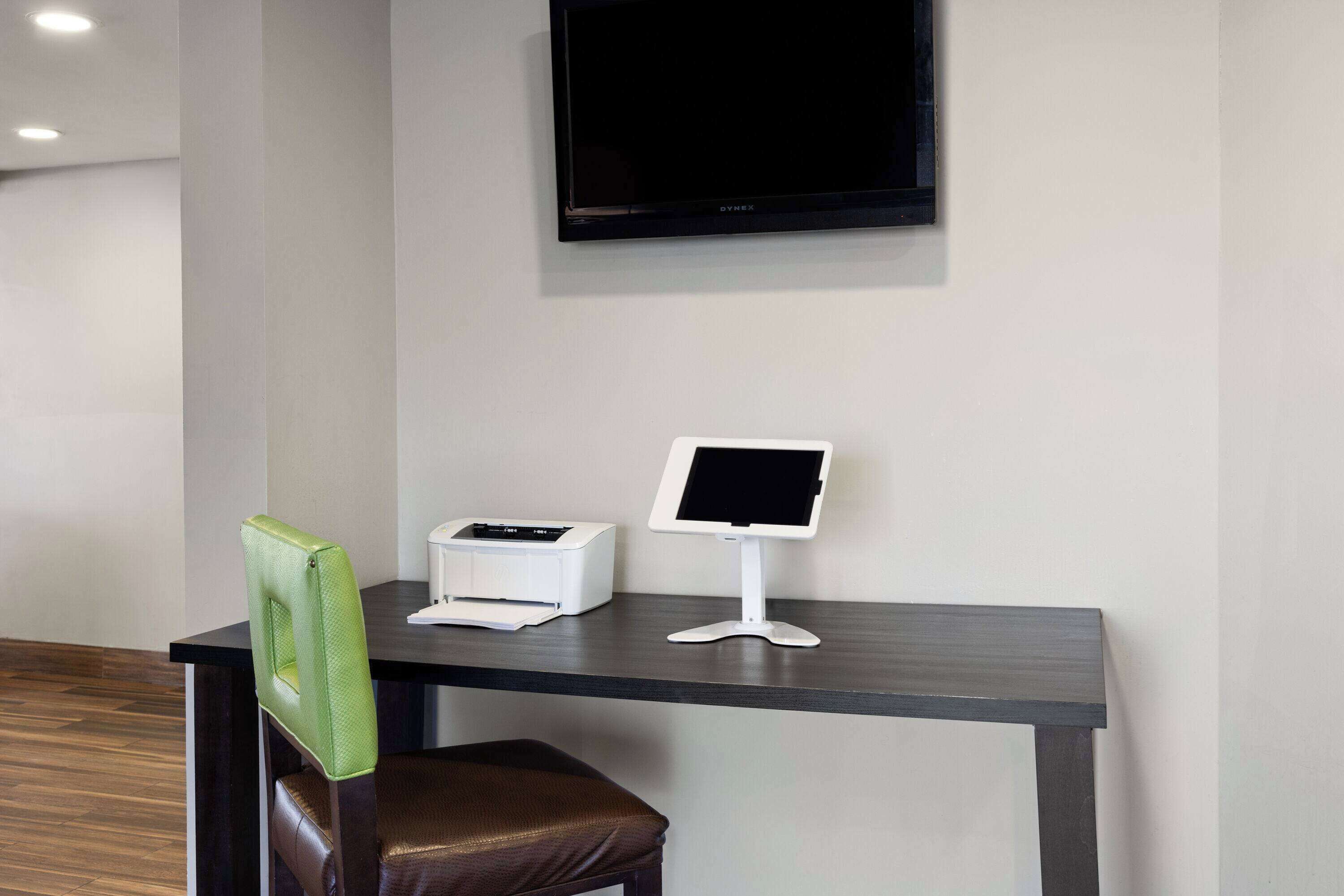 Een receptiebalie met een flatscreen televisie, een printer en een stoel.