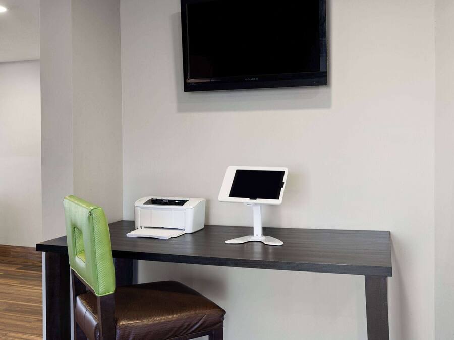 Een receptiebalie met een flatscreen televisie, een printer en een stoel.
