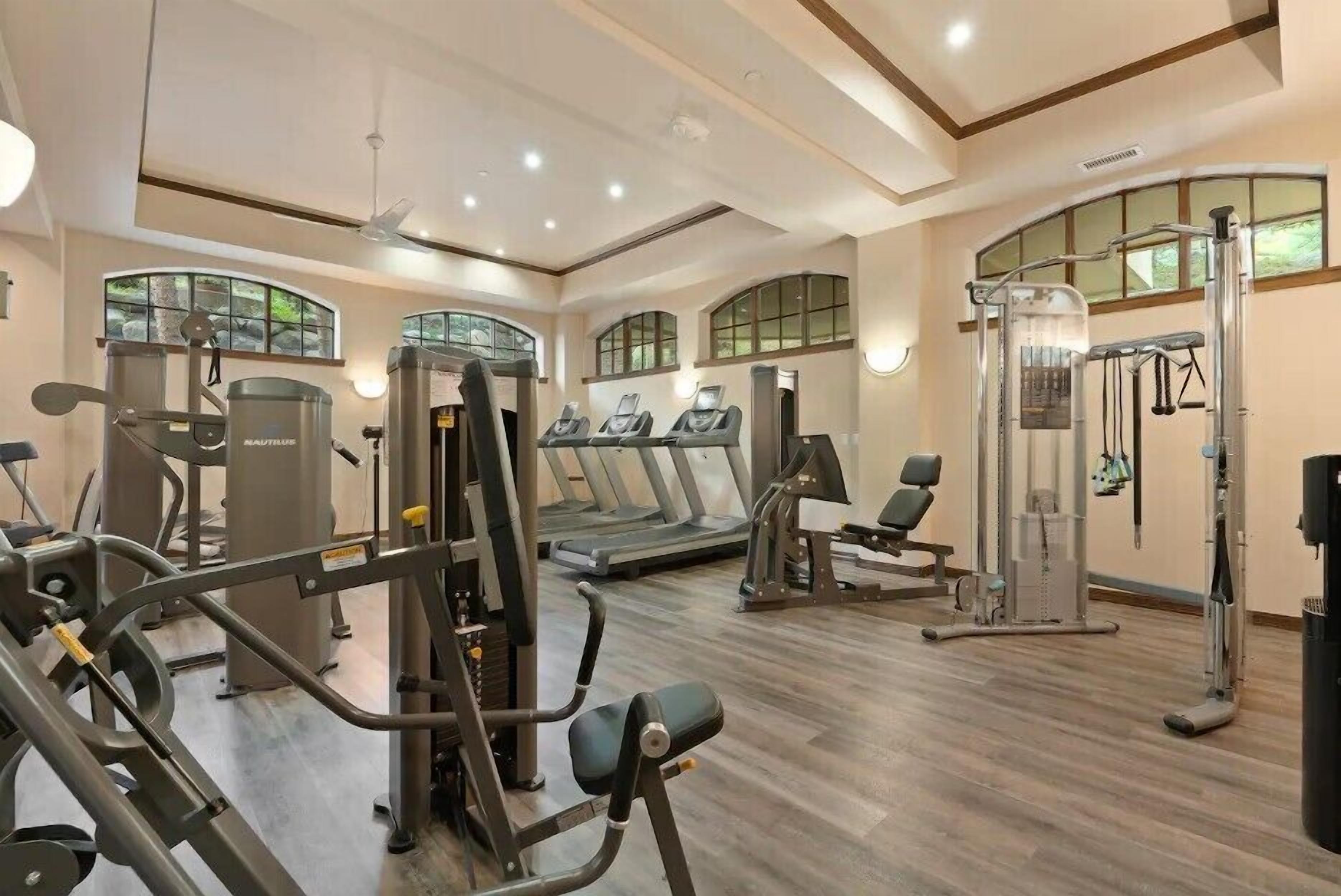 A gym with treadmills, weight machines, and a squat rack.